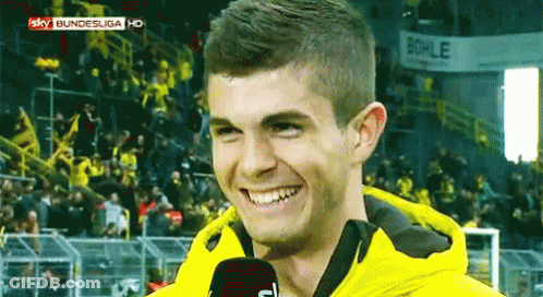 Man In Yellow Jacket Smiling Into Microphone GIF