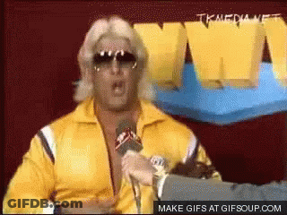 Man In Yellow Jacket Speaking Into Microphone GIF