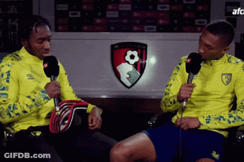 Man In Yellow Jacket Talking Into Microphone GIF