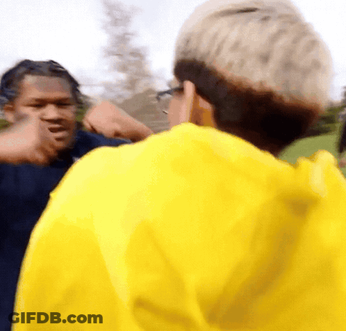 Man In Yellow Jacket Talking To Another Man GIF