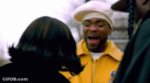 Man In Yellow Jacket Talking To Another Man GIF