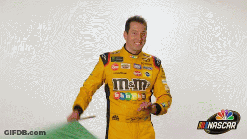 Man In Yellow M&M Racing Uniform Waving Green Flag GIF