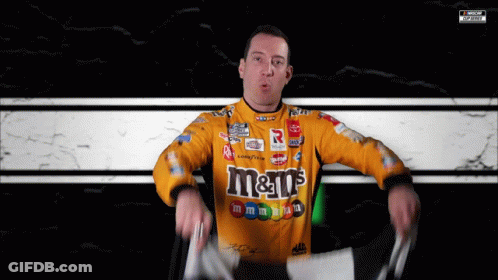 Man In Yellow M&M's Shirt Holding Flag GIF