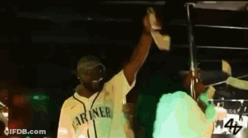 Man In Yellow Mariners Jersey Holding Up Hand GIF
