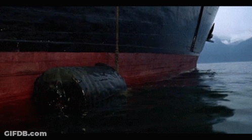 Man In Yellow Mask Holding Stick By Boat GIF