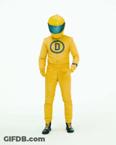 Man In Yellow Racing Suit In Front Of Done Deal Sign GIF