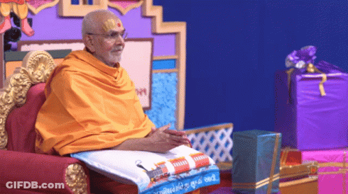 Man In Yellow Robe On Chair With Purple Box GIF