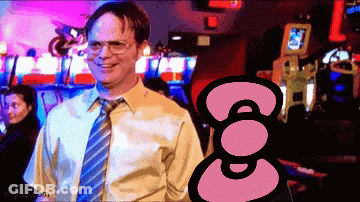 Man In Yellow Shirt And Blue Tie Smiling In Front Of Hello Kitty GIF