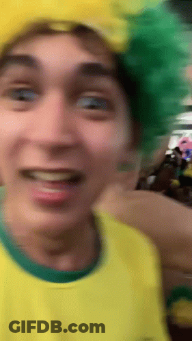 Man In Yellow Shirt And Green Hat Smiling GIF