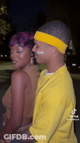 Man In Yellow Shirt And Headband Next To Woman With Purple Hair GIF