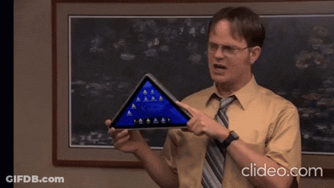 Man In Yellow Shirt And Tie Pointing At Triangle Saying Unleash GIF