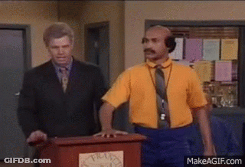 Man In Yellow Shirt At Podium Man In Suit Behind GIF