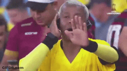Man In Yellow Shirt Covering Mouth GIF