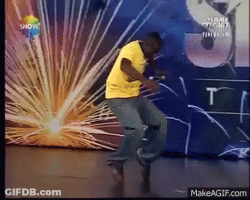 Man In Yellow Shirt Dancing In Front Of Show Wall GIF