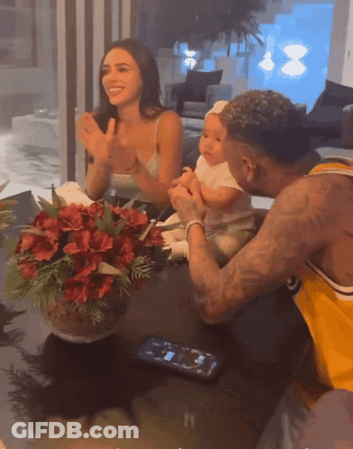 Man In Yellow Shirt Holding Baby While Woman Applauds GIF