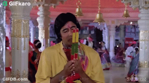 Man In Yellow Shirt Holding Colorful Sticks GIF