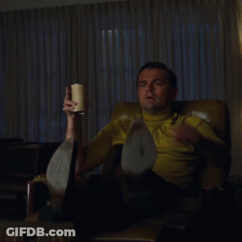 Man In Yellow Shirt Holding Cup And Pointing GIF