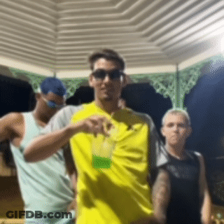 Man In Yellow Shirt Holding Drink GIF
