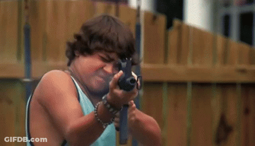 Man In Yellow Shirt Holding Gun Next To Boy In Blue Shirt GIF