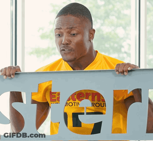 Man In Yellow Shirt Holding Stern Sign GIF