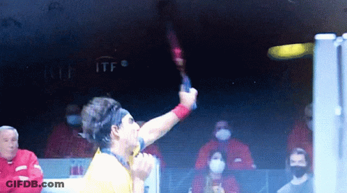 Man In Yellow Shirt Holding Tennis Racket At ITF Sign GIF