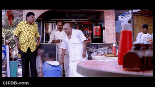 Man In Yellow Shirt In Front Of Coca Cola Machine GIF
