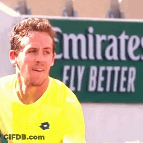 Man In Yellow Shirt In Front Of Emirates Fly Better Sign GIF