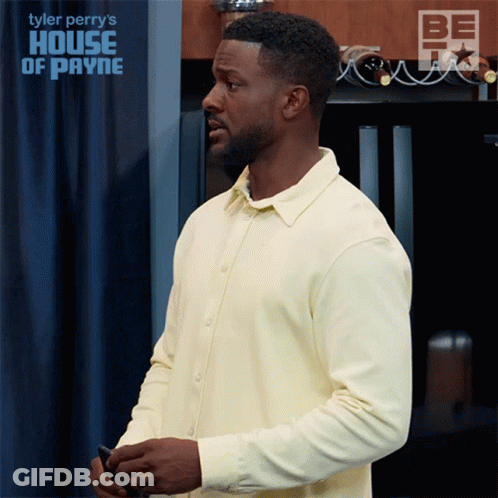 Man In Yellow Shirt In Front Of House Of Payne Sign GIF
