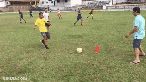 Man In Yellow Shirt Kicking Soccer Ball GIF