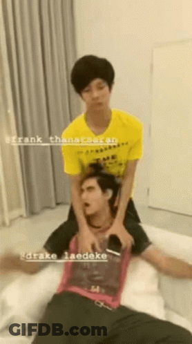 Man In Yellow Shirt Laying On Another Man's Back On Bed GIF