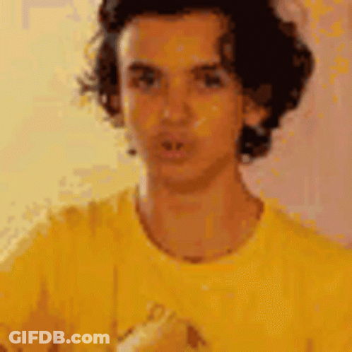 Man In Yellow Shirt Looking At Camera GIF