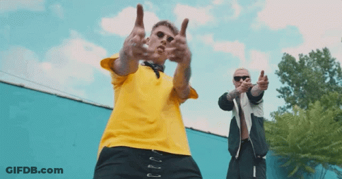 Man In Yellow Shirt Next To Man In Black Jacket Giving Middle Finger GIF