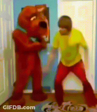 Man In Yellow Shirt Next To Red Teddy Bear GIF