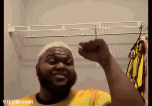 Man In Yellow Shirt Raising Fist GIF