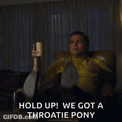 Man In Yellow Shirt Sitting Holding Coffee And Pointing GIF