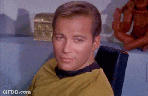 Man In Yellow Shirt Sitting In Front Of Treasure Chest GIF