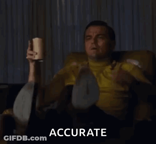 Man In Yellow Shirt Sitting On Couch Holding Cup And Pointing GIF