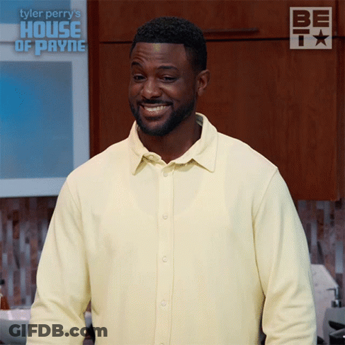 Man In Yellow Shirt Smiling In Front Of House Of Payne Sign GIF
