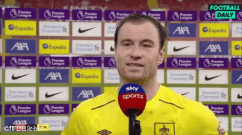 Man In Yellow Shirt Talking Into Microphone GIF