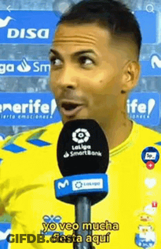 Man In Yellow Shirt Talking Into Microphone Yo Veo Mucha Fiesta Aqui GIF