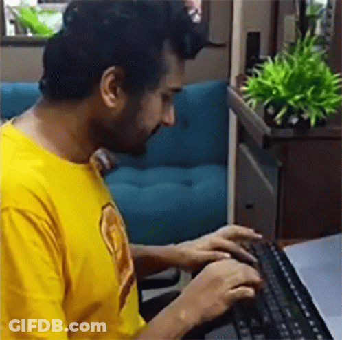 Man In Yellow Shirt Typing On Keyboard GIF