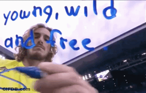 Man In Yellow Shirt Writes Young Wild And Free In Blue Marker GIF
