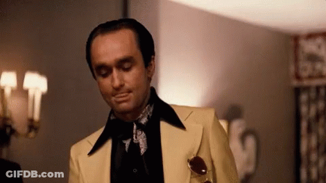 Man In Yellow Suit In Front Of Lamp GIF
