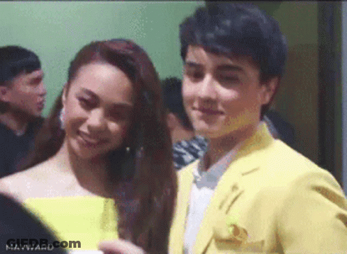 Man In Yellow Suit Next To Woman In Yellow Dress GIF