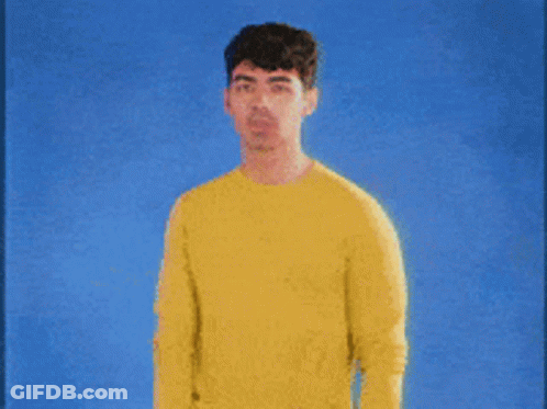 Man In Yellow Sweater Against Blue Background GIF