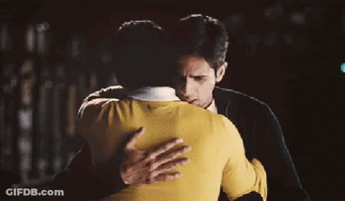 Man In Yellow Sweater Hugging Man In Black Jacket GIF