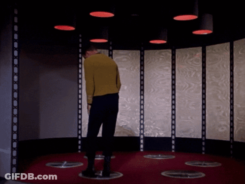 Man In Yellow Sweater In Room With Red Lights GIF