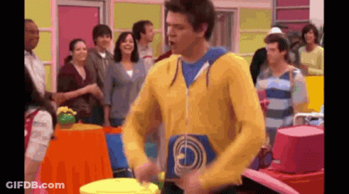 Man In Yellow Sweatshirt Playing Drum In Front Of Crowd GIF