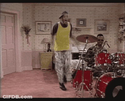 Man In Yellow Tank Top Dancing In Front Of Drum Set GIF