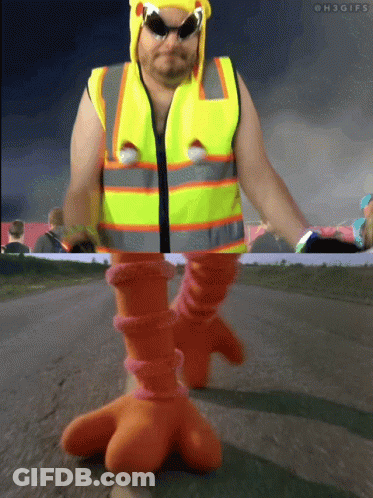 Man In Yellow Vest And Orange Boots Walking GIF